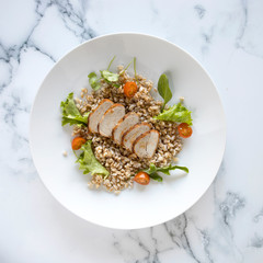 Sliced Pork Tenderloin and Wholegrain Salad on a Marble Background with room for Copy