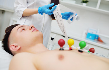 Electrocardiogram, ECG in hand. Clinic of Cardiology heart rate and pulse test closeup. Cardiogram...