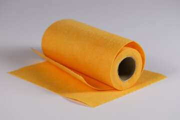 Roll of disposable fabric napkins in orange on a light background