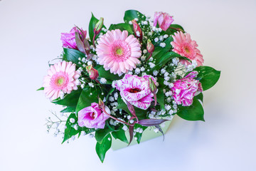 Beautiful bouquet of gerberas and eustomas on a light background. Pink-green flower arrangement