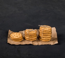 Round shortbread cookies in the shape of coins on a dark gray background
