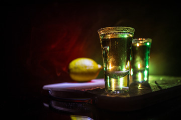 Club drink concept. Tasty alcohol drink cocktail tequila with lime and salt on vibrant dark background or glasses with tequila at a bar