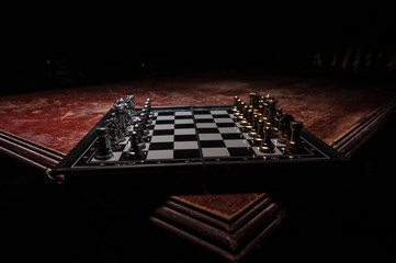 Chess figures on a dark background with smoke and fog. Selective focus