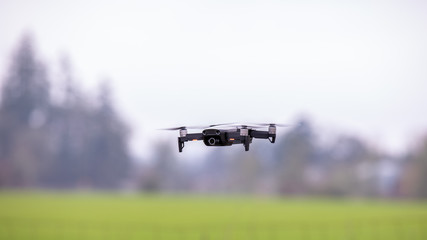 Drone hovering above the ground against blurred background