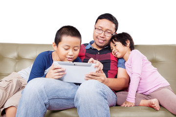 Fototapeta premium Man teaching his children how to use tablet wisely