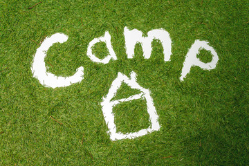The word Camp. Pine needle lining. Ecology concept. Hands draw. Image on a green background.