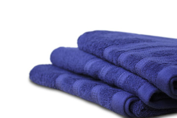 pile of clean terry bath towels of purple towels, close-up, on a light background, concept of...