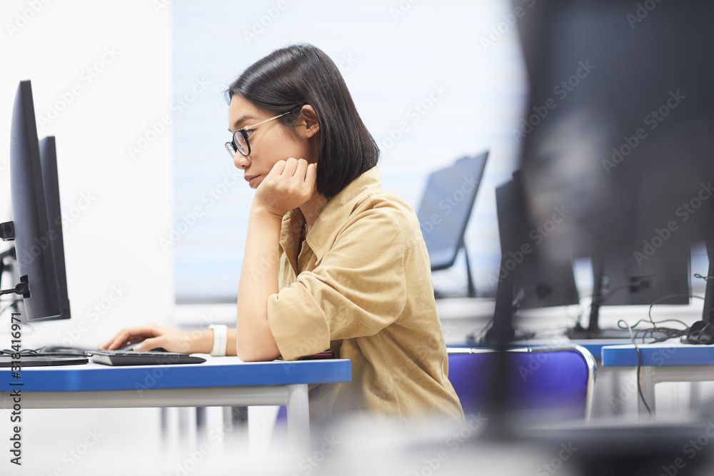 Canvas Prints side view portrait of young asian woman using computer in class of college library, copy space