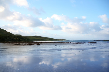 beautiful seascape with blue waves, clouds reflected in the water and mountains in the distance, travel concept, ecology