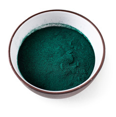 Spirulina algae powder in a clay cup isolated on white background. Top view. Super food concept 