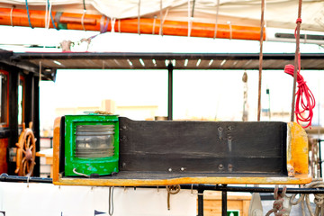 Green starboard navigation light on a classic sailing ship.
