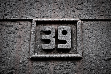 Number 39, thirty-nine, stone relief in gray sandstone.