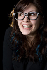 Fototapeta na wymiar A dorky girl with goofy glasses on black background.