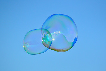 Low Angle View Of Bubbles Flying Against Clear Blue Sky