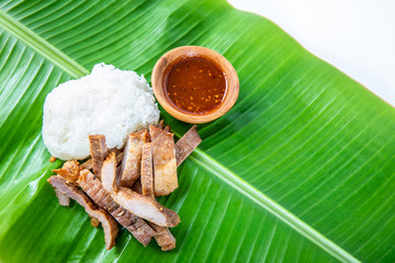 Sticky rice, fried pork and Thai spicy(Thai-Isaan dipping sauce) on banana leaf.