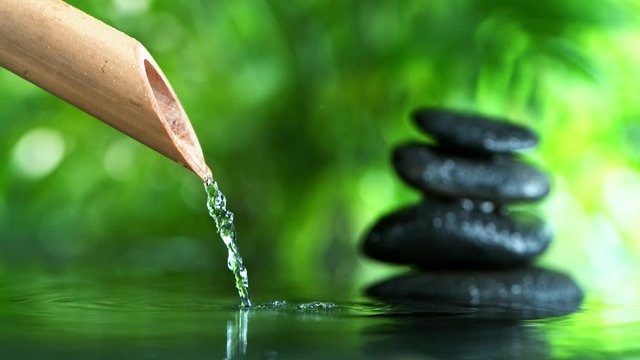 Super slow motion of leaking water stream from bamboo, spa and wellness concept. Filmed on very high speed cinema camera, 1000 fps.