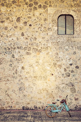 Naklejka premium Blue bike on an old stone wall