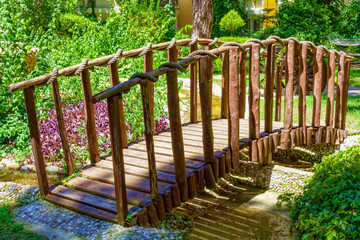 Wooden bridge over a stream, park architecture.