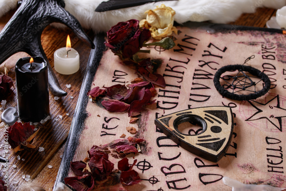 Wall mural spiritual board ouija with candles close-up. mystical ritual of calling dead spirits. macro.