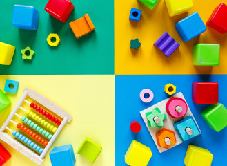 Wooden kids toys on colourful paper. Educational toys blocks. Toys for kindergarten, preschool or daycare. Copy space for text. Top view, mock up