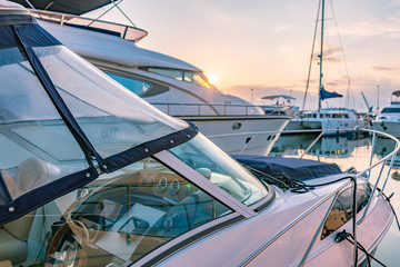 Cockpit and control panel of a small marine boat. Beautiful clear sunset in the sea harbor with...