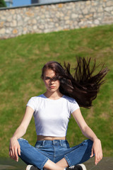 Young beautiful teenager girl posing against summer park, bright sunny weather