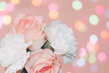 Pink roses and white asters on a pink background with bokeh.