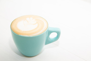Soft focus Hot coffee cup of latte art on white wooden table in the morning.