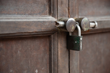 selective focus of traditional wooden door and rusty lock master key at asian temple.