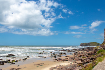 Fototapeta na wymiar rocks, sand and sea of the city of Torres beach on a blue sky day