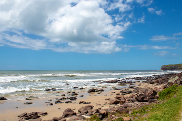 Fototapeta na wymiar rocks, sand and sea of the city of Torres beach on a blue sky day