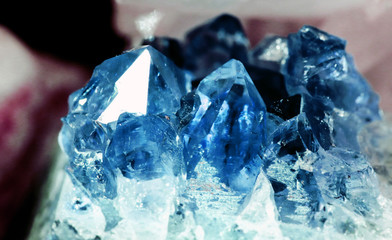 Texture of gemstone cluster closeup as a part of geode filled with rock blue Amethyst crystals.