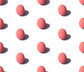 Pattern made of pink eggs with hard light on white background