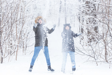 Fototapeta na wymiar Young couple playing with snow in winter park