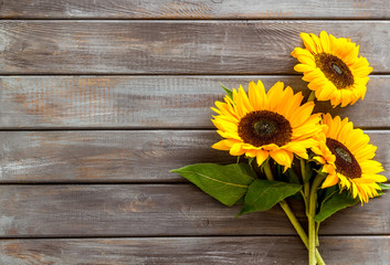 Bouquet of sunflowers on dark wooden background top-down copy space