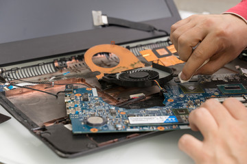 disassembled dusty laptop. the master cleans the processor