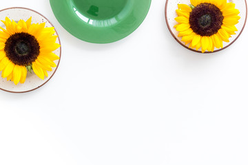 Dinning table decorated with sunflowers, white background top-down copy space
