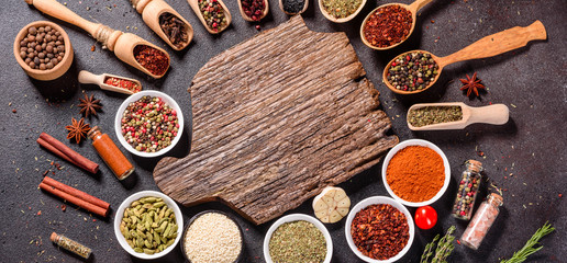 Obraz na płótnie Canvas Spices and herbs over black stone background. Top view with free space for menu or recipes
