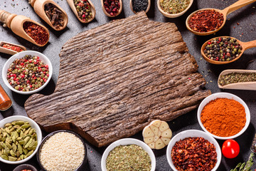 Spices and herbs over black stone background. Top view with free space for menu or recipes