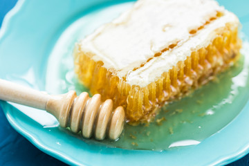 Honey with wooden honey dipper and honeycombs