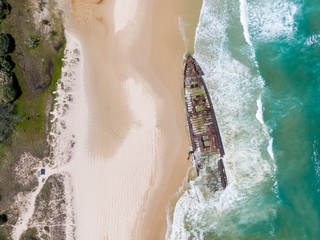 High angle aerial bird's eye drone view of the SS Maheno shipwreck, an ocean liner which ran...