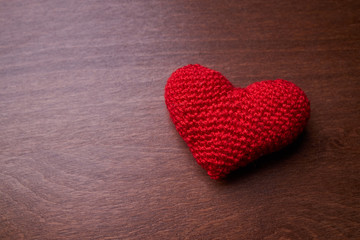 Fototapeta premium red heart made from wool on a dark wooden background. copy space. romance and valentine day concept.