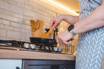 man frying on pan at the kitchen. cooking concept