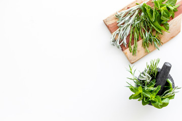 Make seasoning and condiments. Herbs in mortar on white background top-down copy space