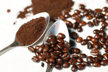 Closeup coffee beans and coffee cream on the spoon for the good taste coffee on white background, coffee seeds 