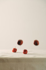 Falling red apples on table background