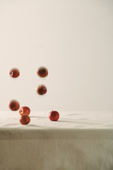 Falling red apples on table background