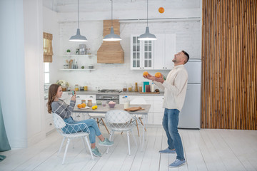 Dad and daughter have fun in the kitchen after breakfast.