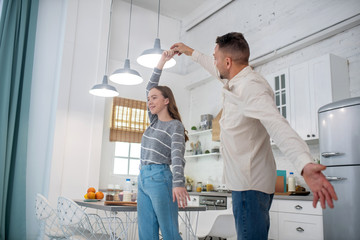 Daughter teenager dancing with dad in the kitchen.