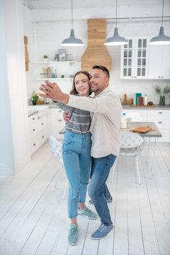 Dad And His Teenage Daughter Are Dancing In The Kitchen.